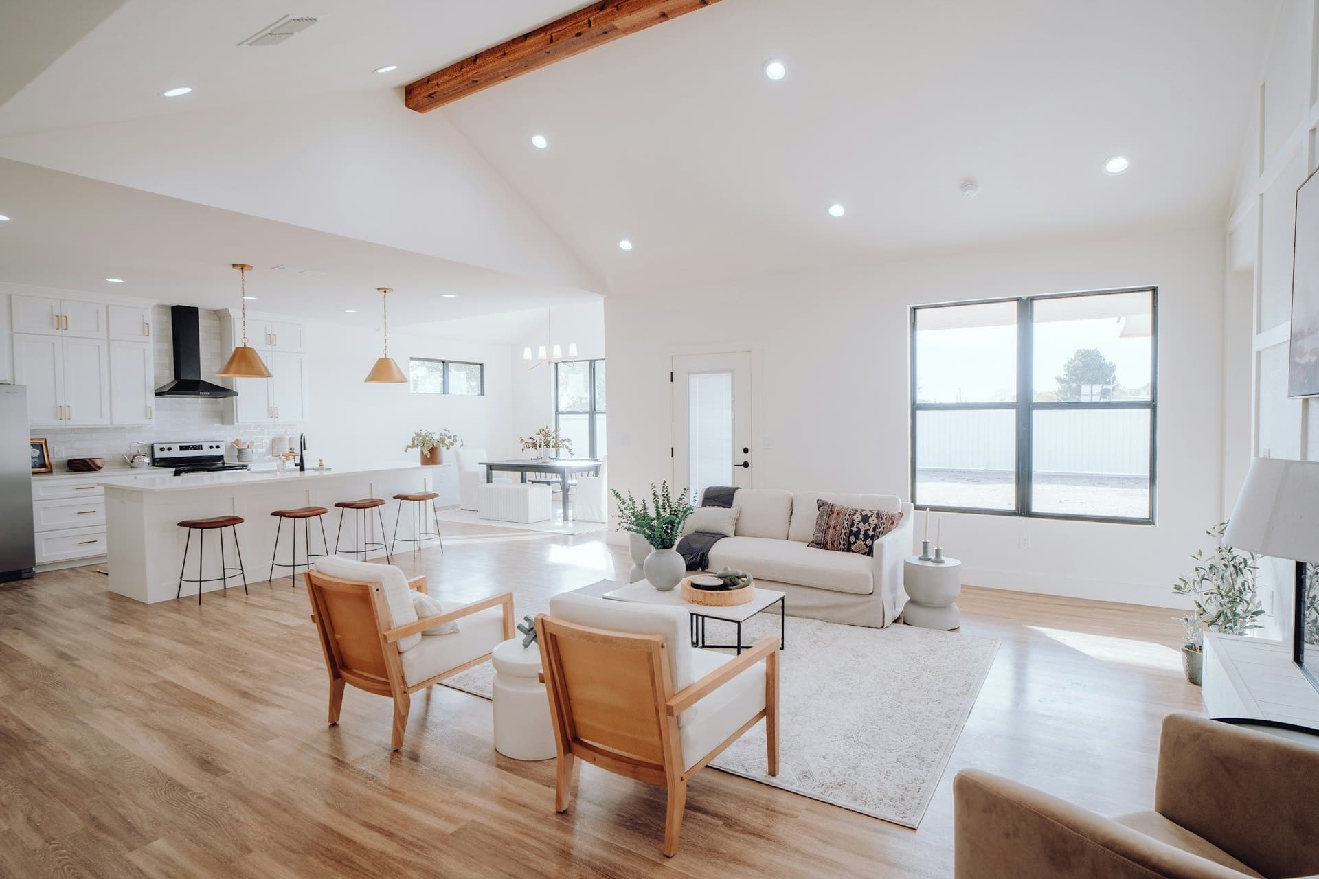 A renovated open-plan living room and kitchen with wooden floors and a beamed ceiling