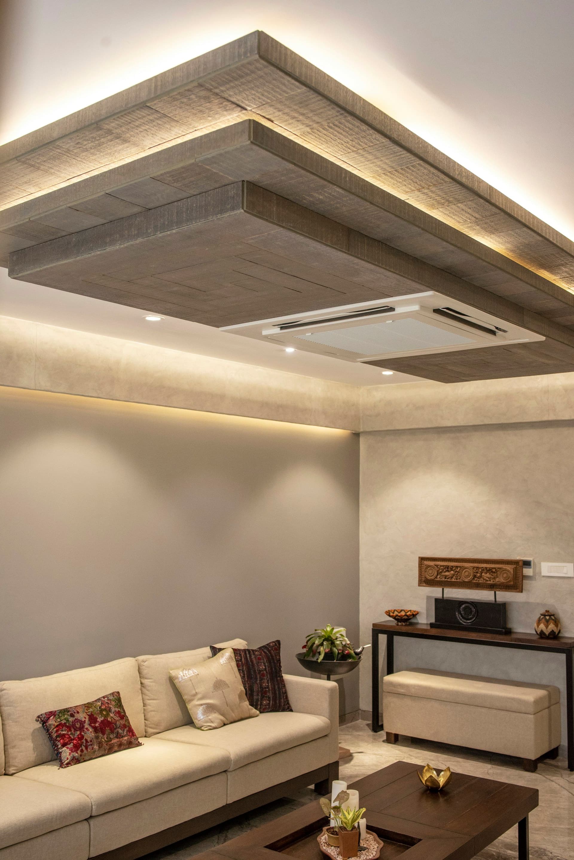 Living room with a stepped false ceiling, soft cove lighting and a ceiling-mounted air conditioner